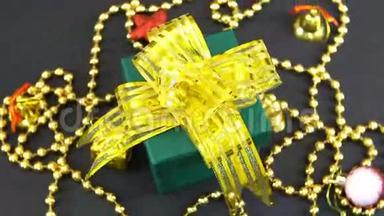 美丽的圣诞绿色礼品盒，<strong>金色</strong>的<strong>蝴蝶结</strong>和装饰旋转在黑色的背景。 无缝可循环。
